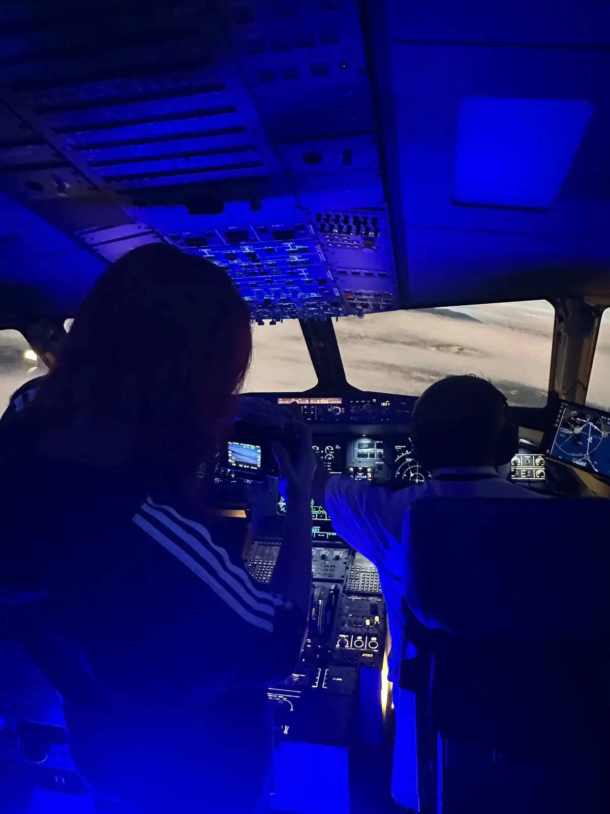 Two pilots flying the Airbus A320 simulator at night